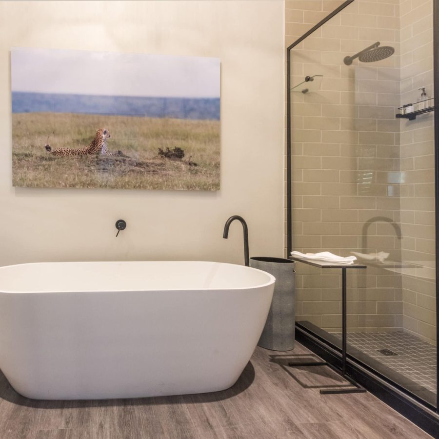 free standing bath and large shower with an image of cheetahs on the wall