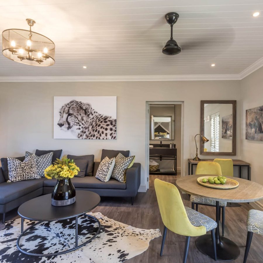 a beautifully decorated room with an african theme, lounge area and 3-seater table