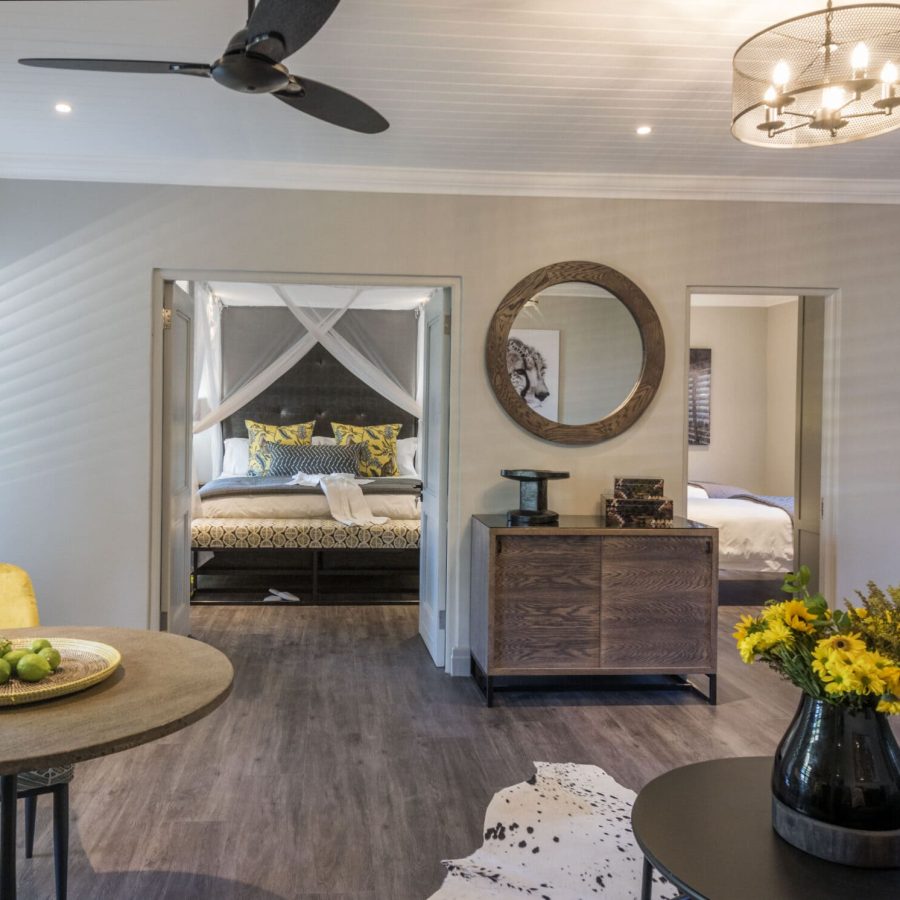 a beautifully decorated room with an african theme, large 4-poster king size bed draped mosquito netting, and kitchen