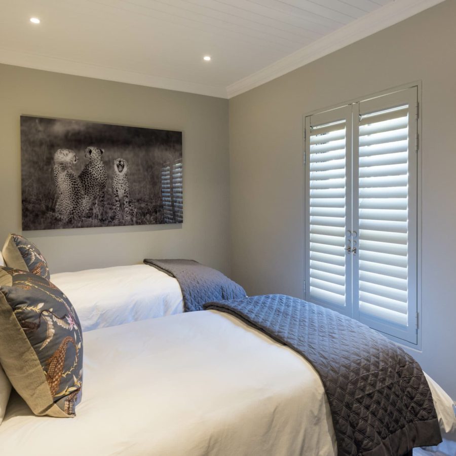 two single beds in a room with an image of cheetahs on the wall